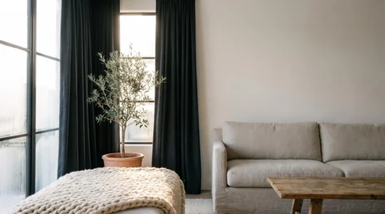 Salon acogedor con cortinas termicas gruesas semiabiertas dejando entrar luz de invierno junto a una ventana